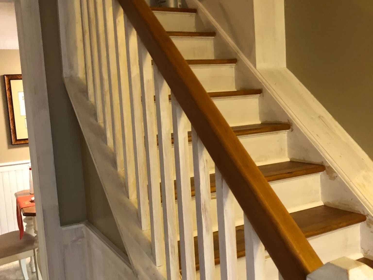 Finished staircase with white painted balusters, stained oak treads and a stained oak handrail